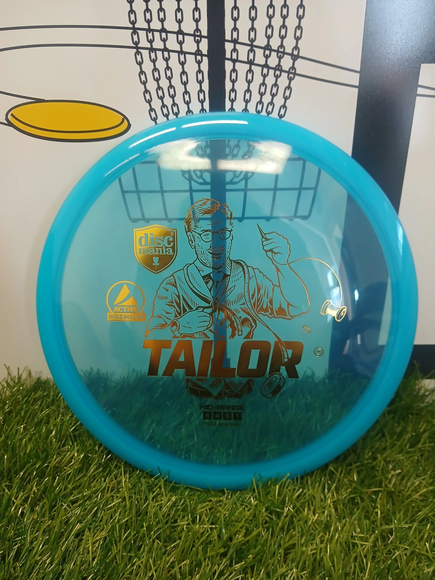 Blue Discmania Tailor mid-range disc golf disc on grass, PDGA approved, Active Premium plastic