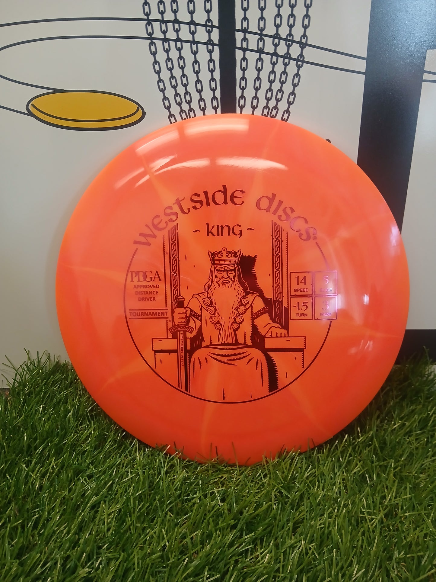 Westside Discs King orange distance driver disc on grass, PDGA approved for disc golf