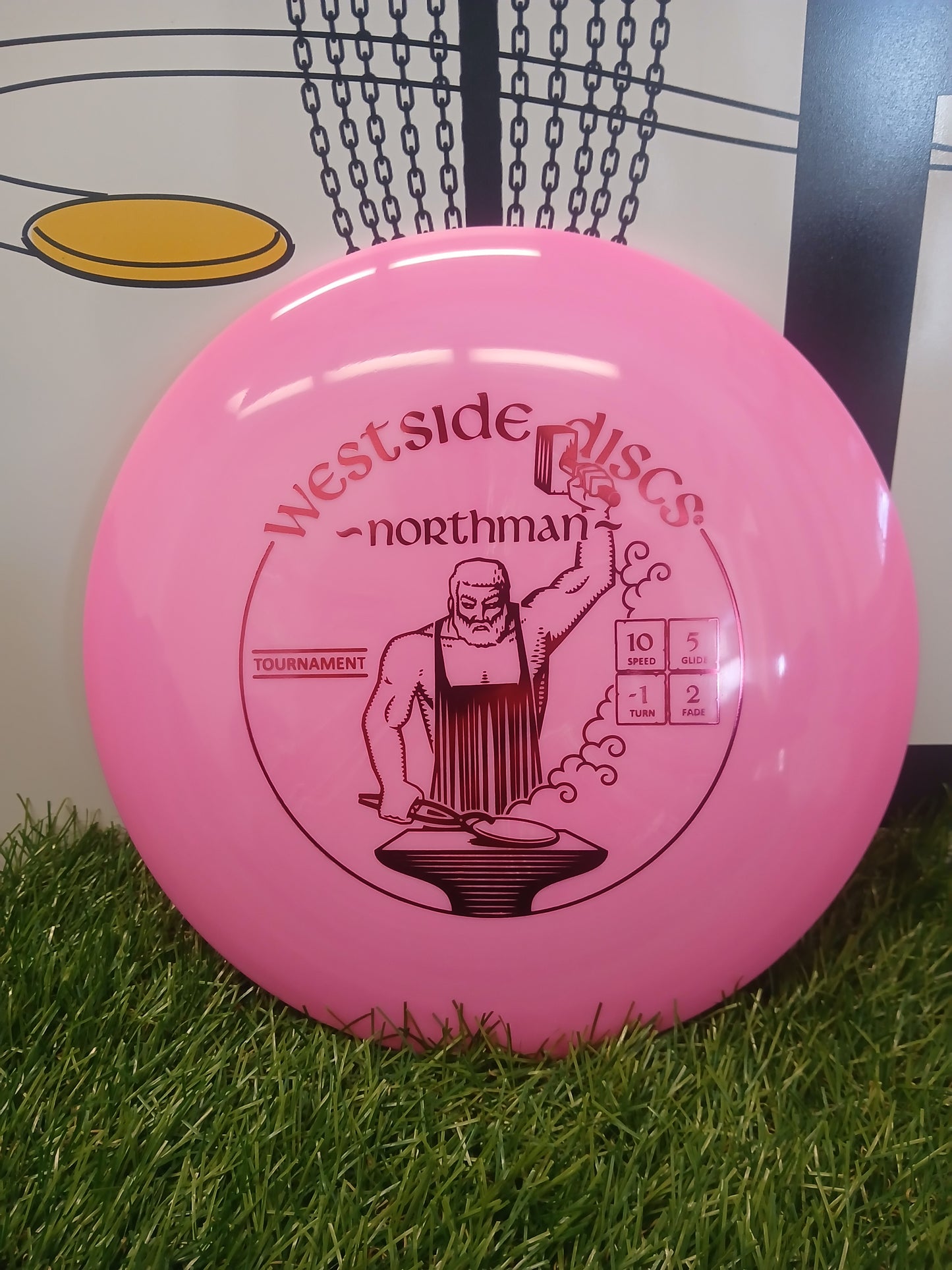 Pink Westside Discs Northman disc golf disc on grass, tournament model with speed 10, glide 5, turn -1, fade 2