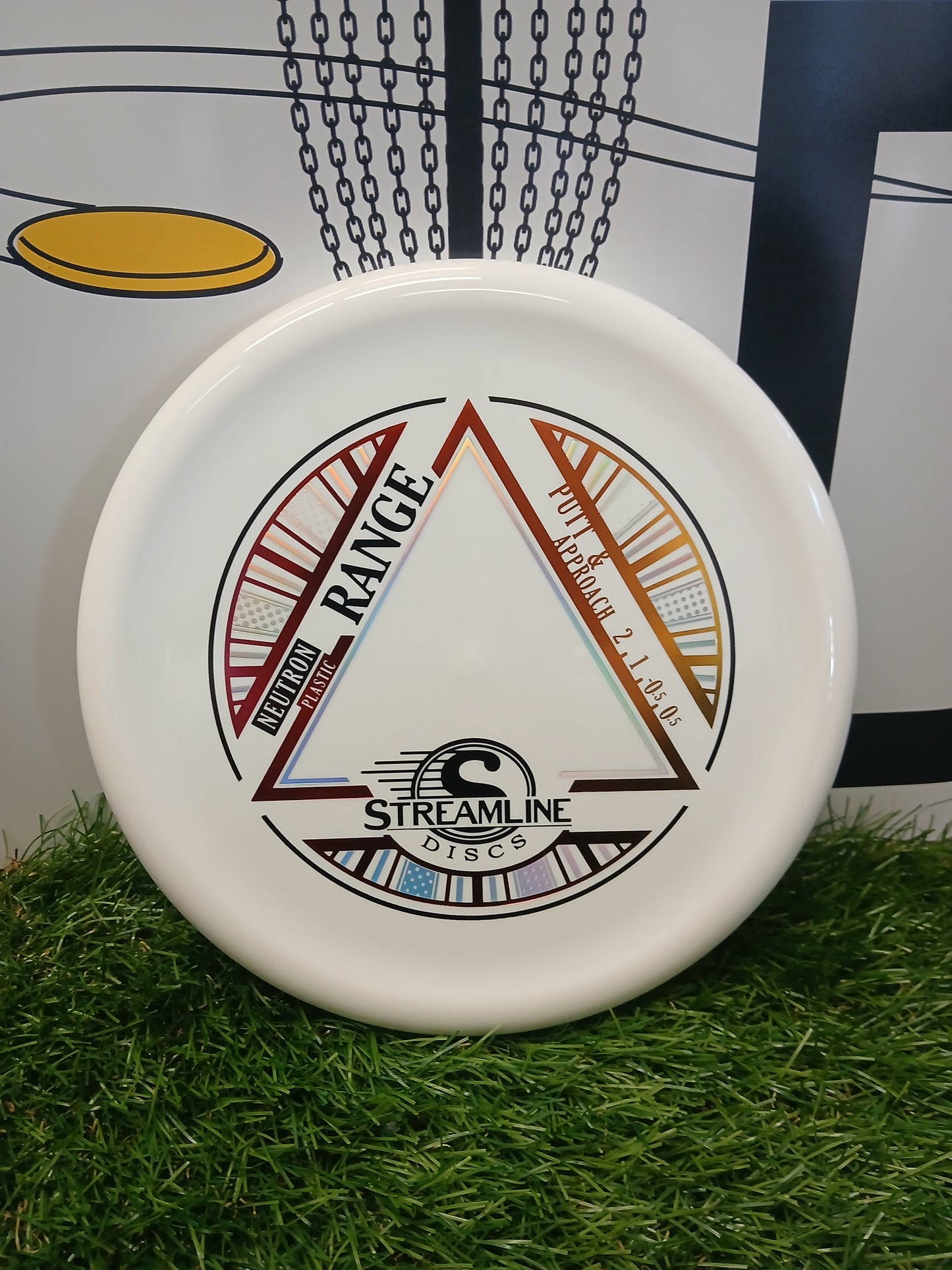 Streamline Discs Neutron Range putter & approach disc on grass, ideal for disc golf games and training.