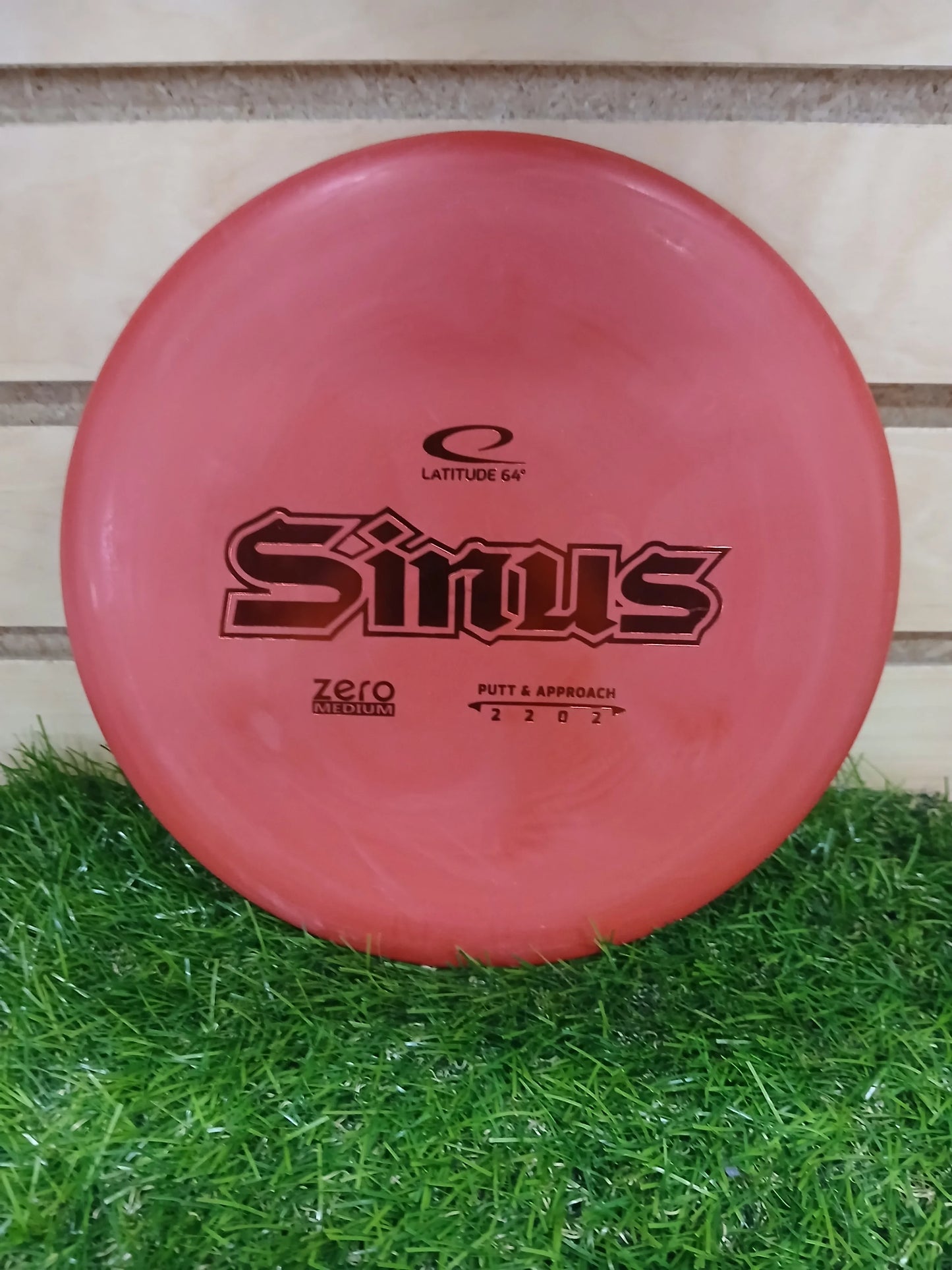 Latitude 64 Sinus Zero Medium putter disc golf disc on grass, ideal for putt and approach shots.