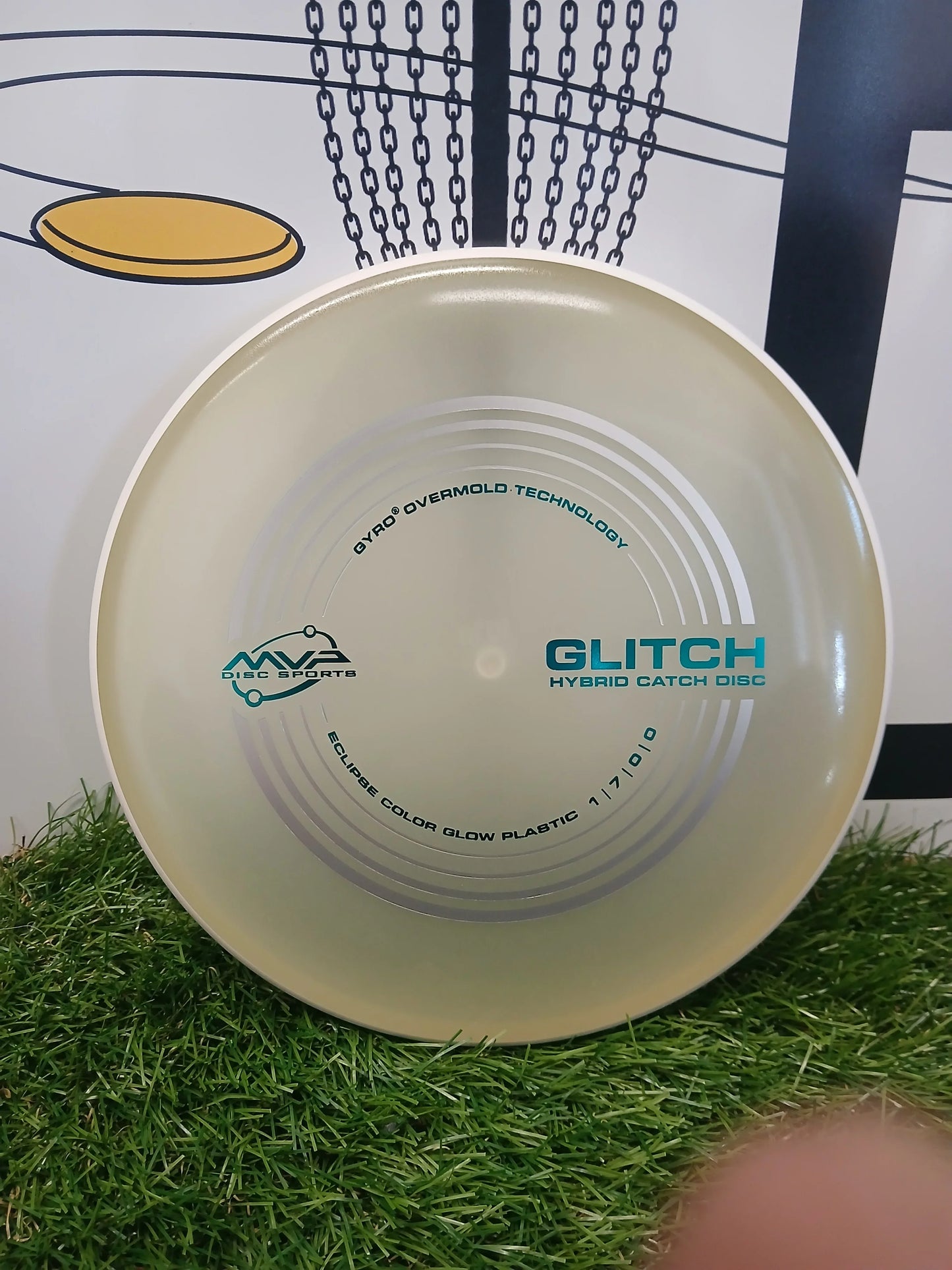 MVP Glitch hybrid catch disc golf disc on grass, featuring Gyro Overmold Technology and Eclipse glow plastic