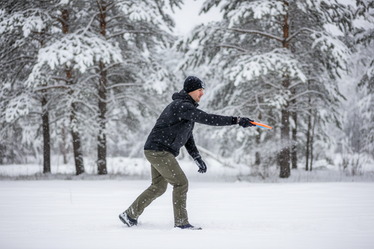 Man throwing disc golf disc in snowy forest, winter disc golf game
