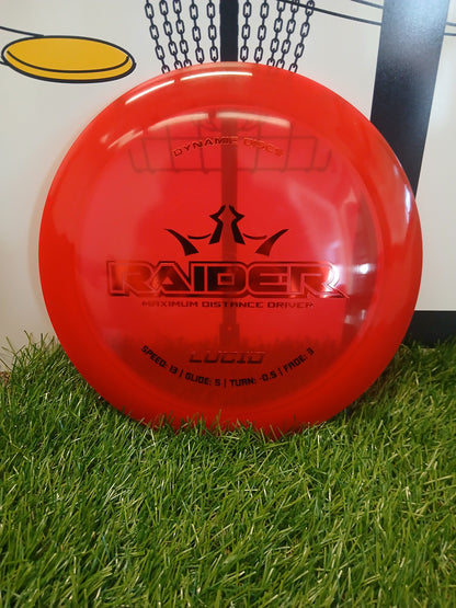 Red Dynamic Discs Raider maximum distance driver disc on grass, Lucid plastic