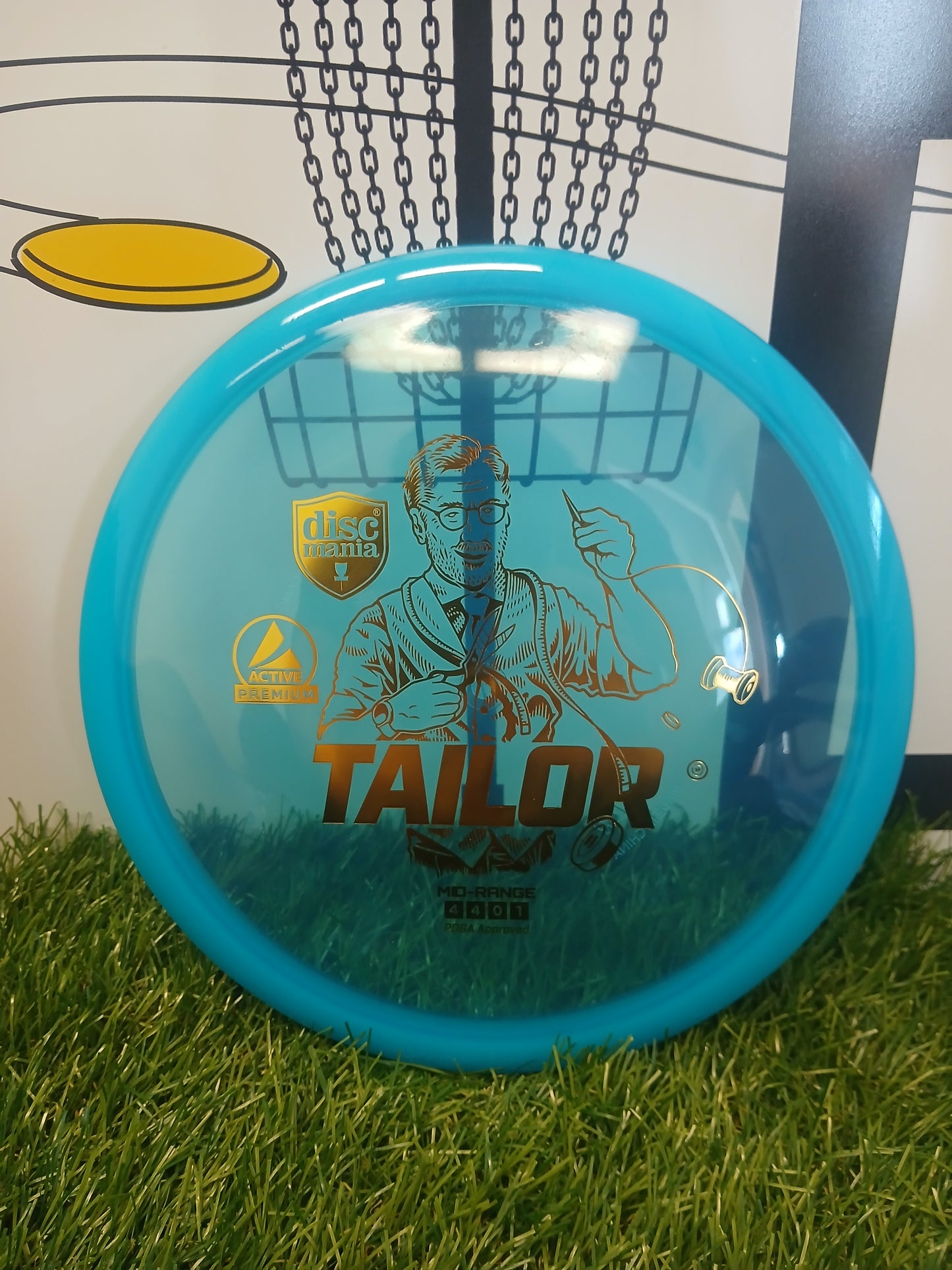Blue Discmania Tailor mid-range disc golf disc on grass, PDGA approved, Active Premium plastic