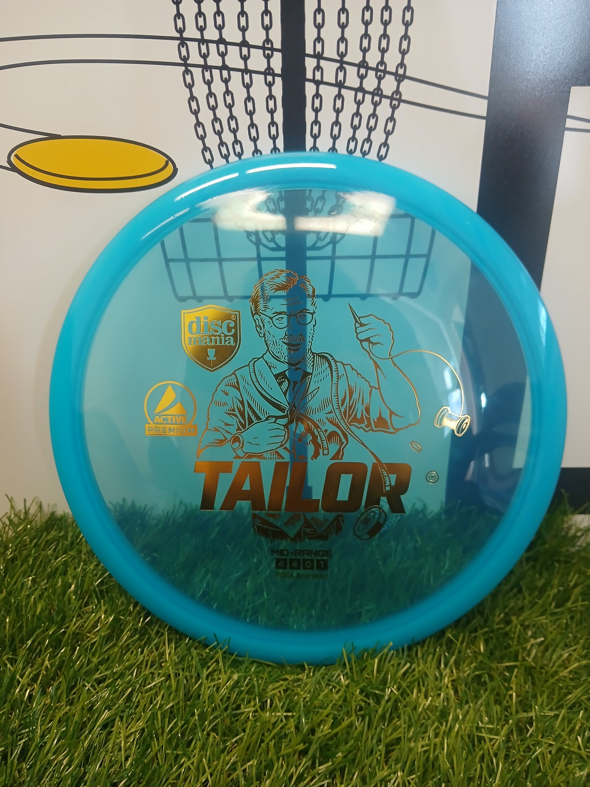 Blue Discmania Tailor mid-range disc golf disc on grass, PDGA approved, Active Premium plastic
