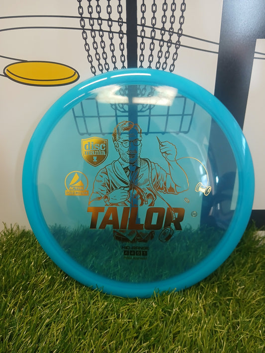 Blue Discmania Tailor mid-range disc golf disc on grass, PDGA approved, Active Premium plastic