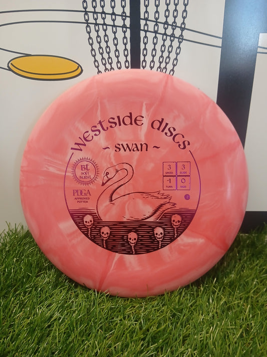 Pink Westside Discs Swan putter on grass, PDGA approved with swan and skull design