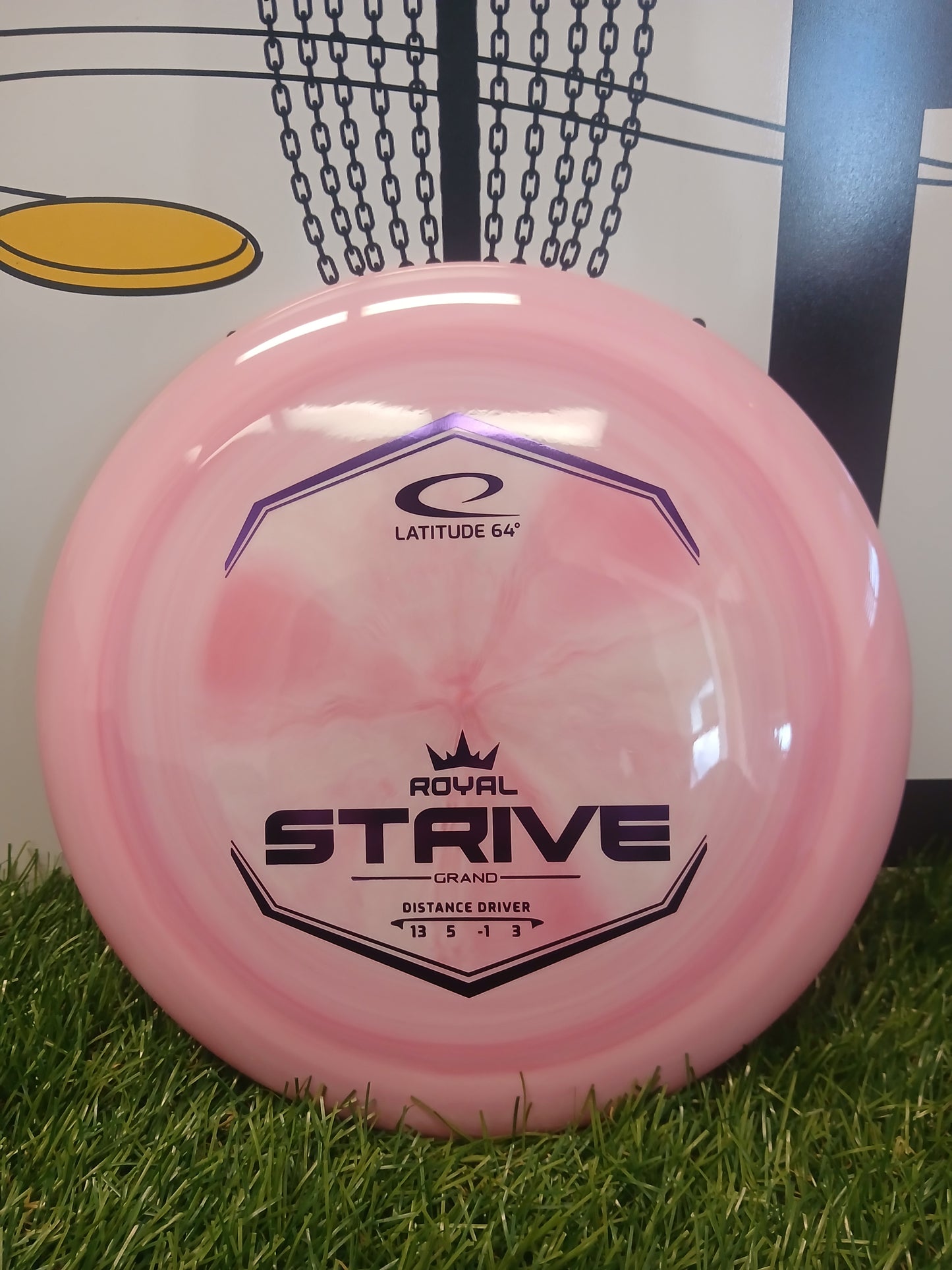 Pink Latitude 64 Royal Strive Grand distance driver disc golf disc on grass