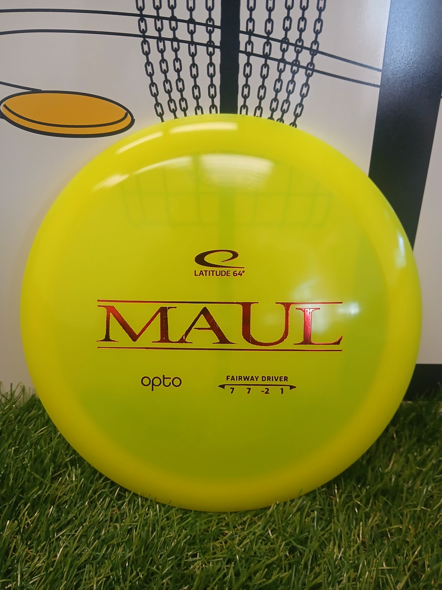 Bright yellow Latitude 64° Maul Opto fairway driver disc golf disc on grass