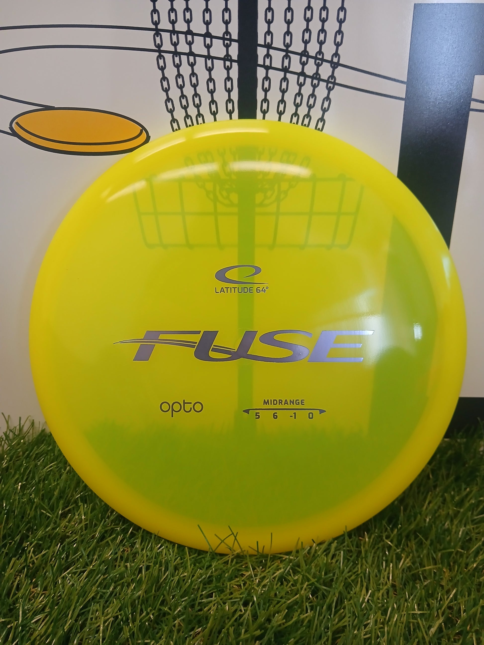 Latitude 64° Fuse Opto midrange disc golf disc on grass, bright yellow-green