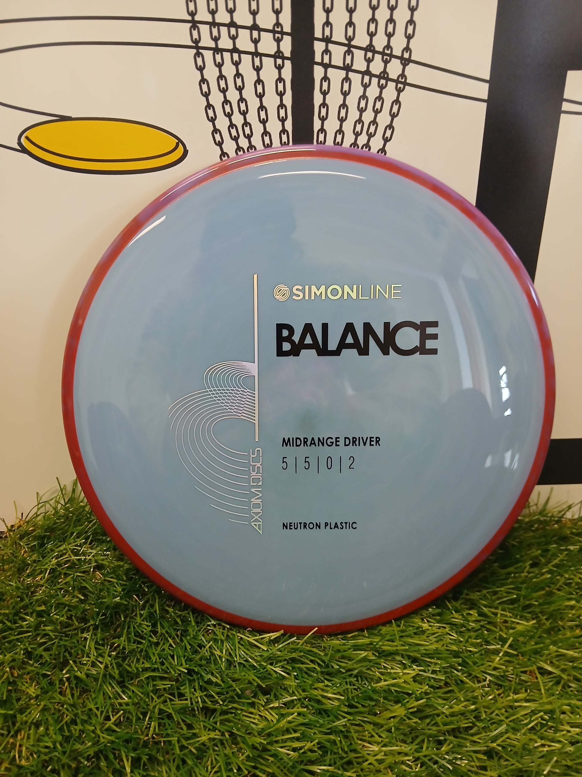 Simonline Balance midrange driver disc golf disc in neutron plastic on grass, ideal for disc golf enthusiasts