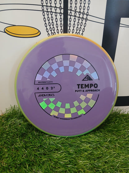 Purple Axiom Discs Tempo putter disc on grass, Neutron plastic, for disc golf putt & approach shots.