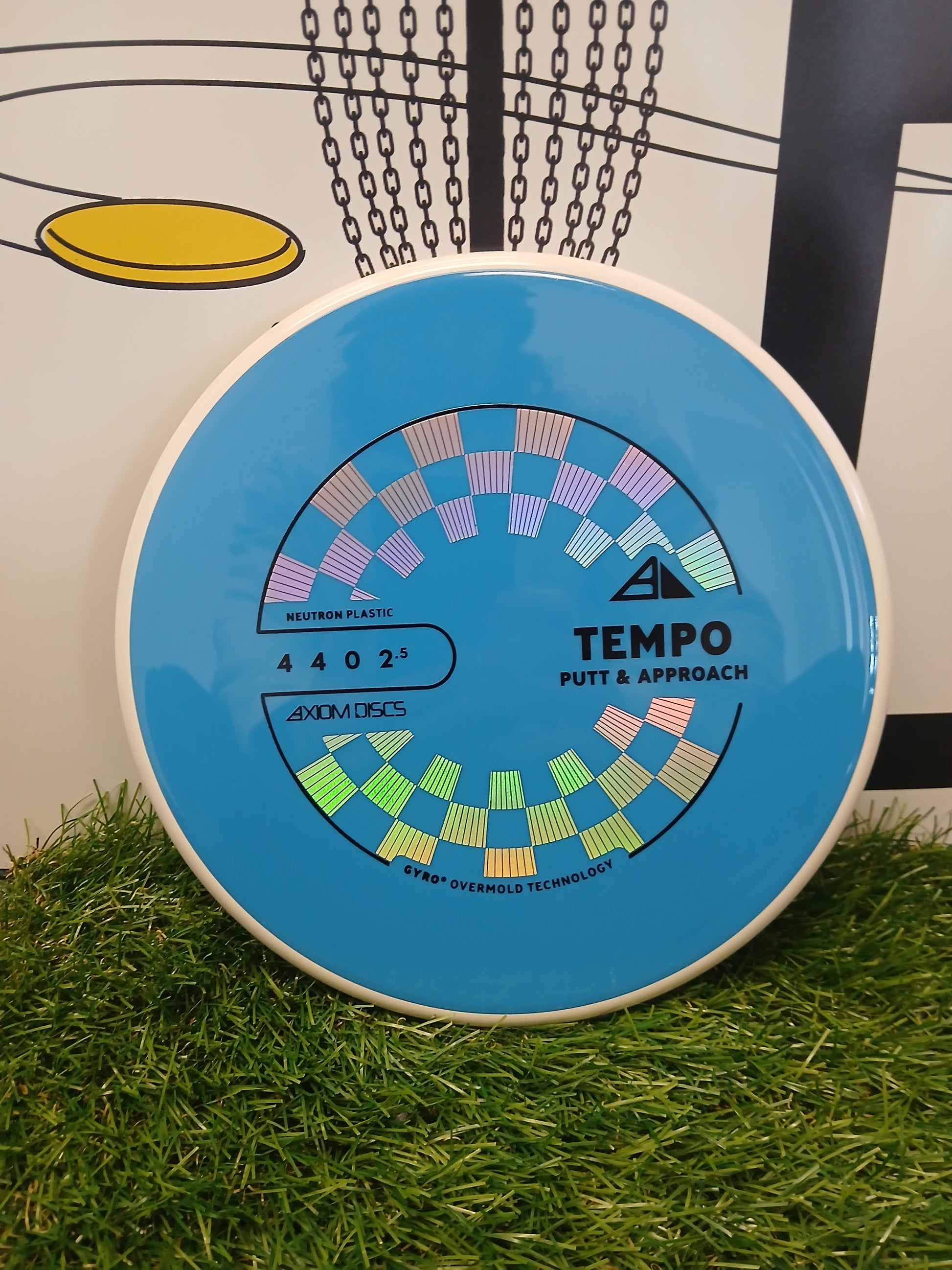 Axiom Discs Tempo putter disc in blue Neutron plastic, designed for putt & approach shots, resting on grass.