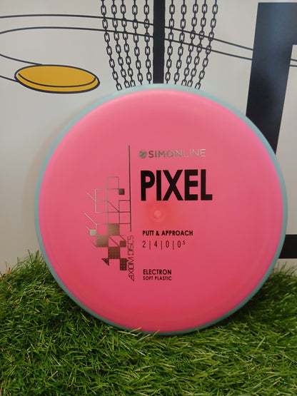 Pink Simonline Pixel putter disc for disc golf, Electron soft plastic, on grass near basket