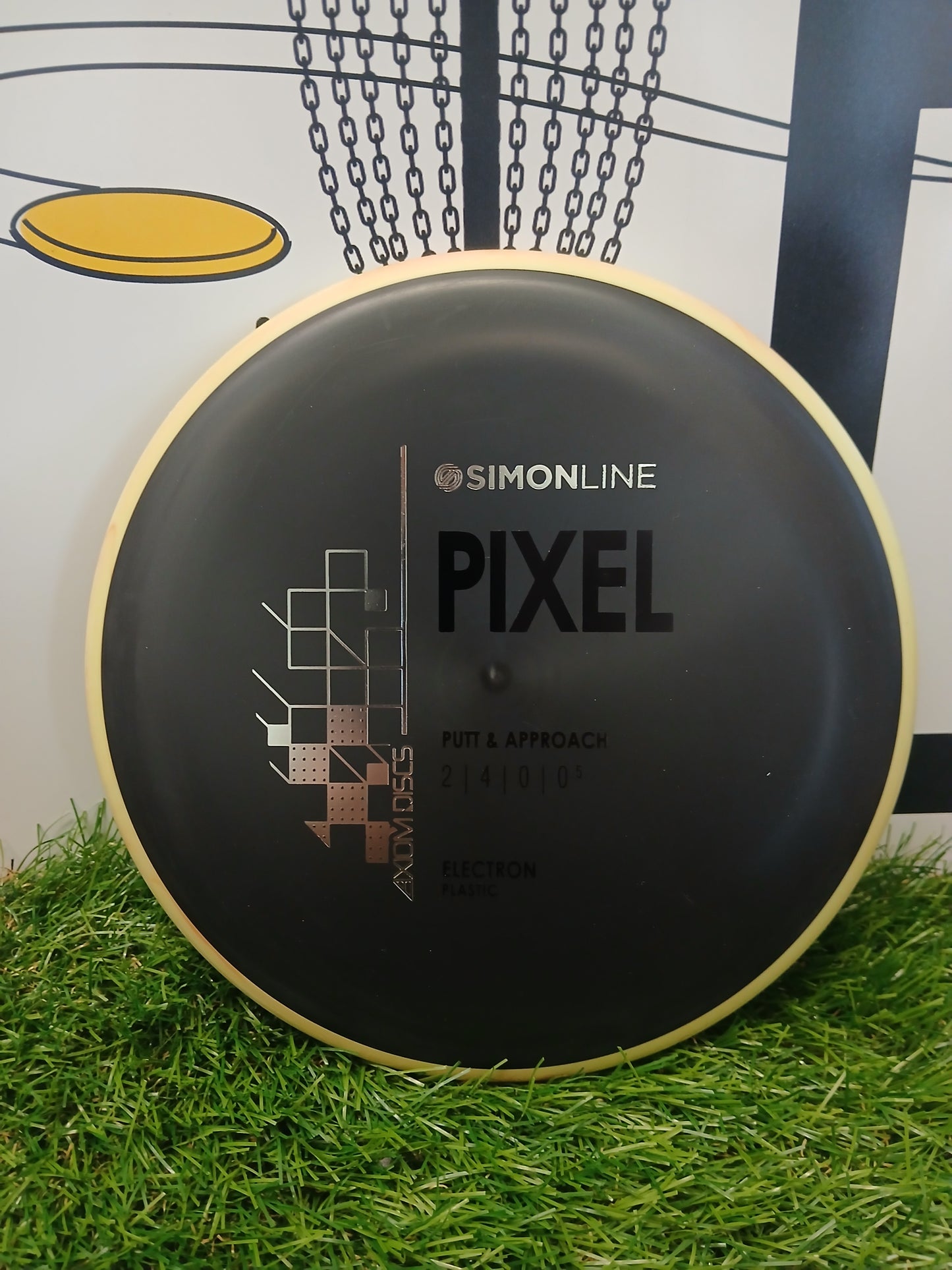 Simonline Pixel putter disc golf disc, Electron plastic, for putt & approach, on grass with chain basket background
