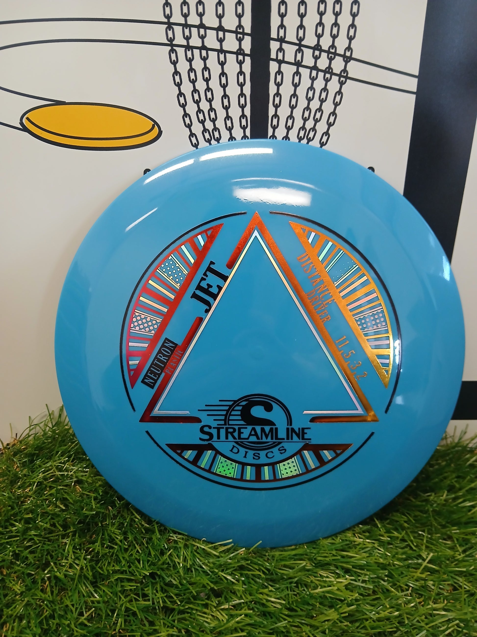 Blue Streamline Discs Jet distance driver on grass with chain basket background