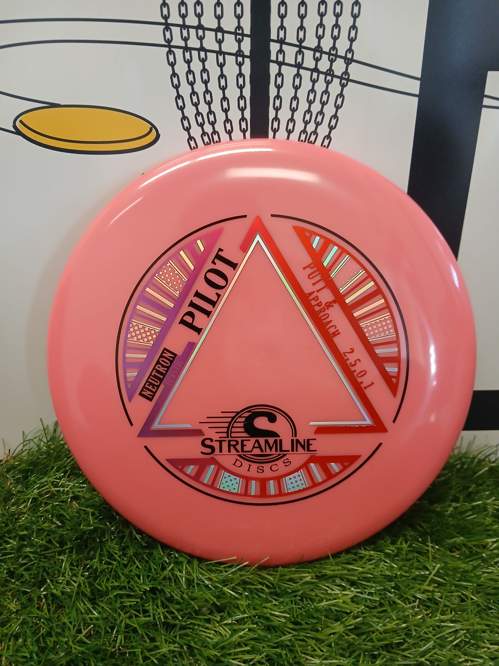 Pink Streamline Discs Pilot Neutron putter for disc golf on artificial grass