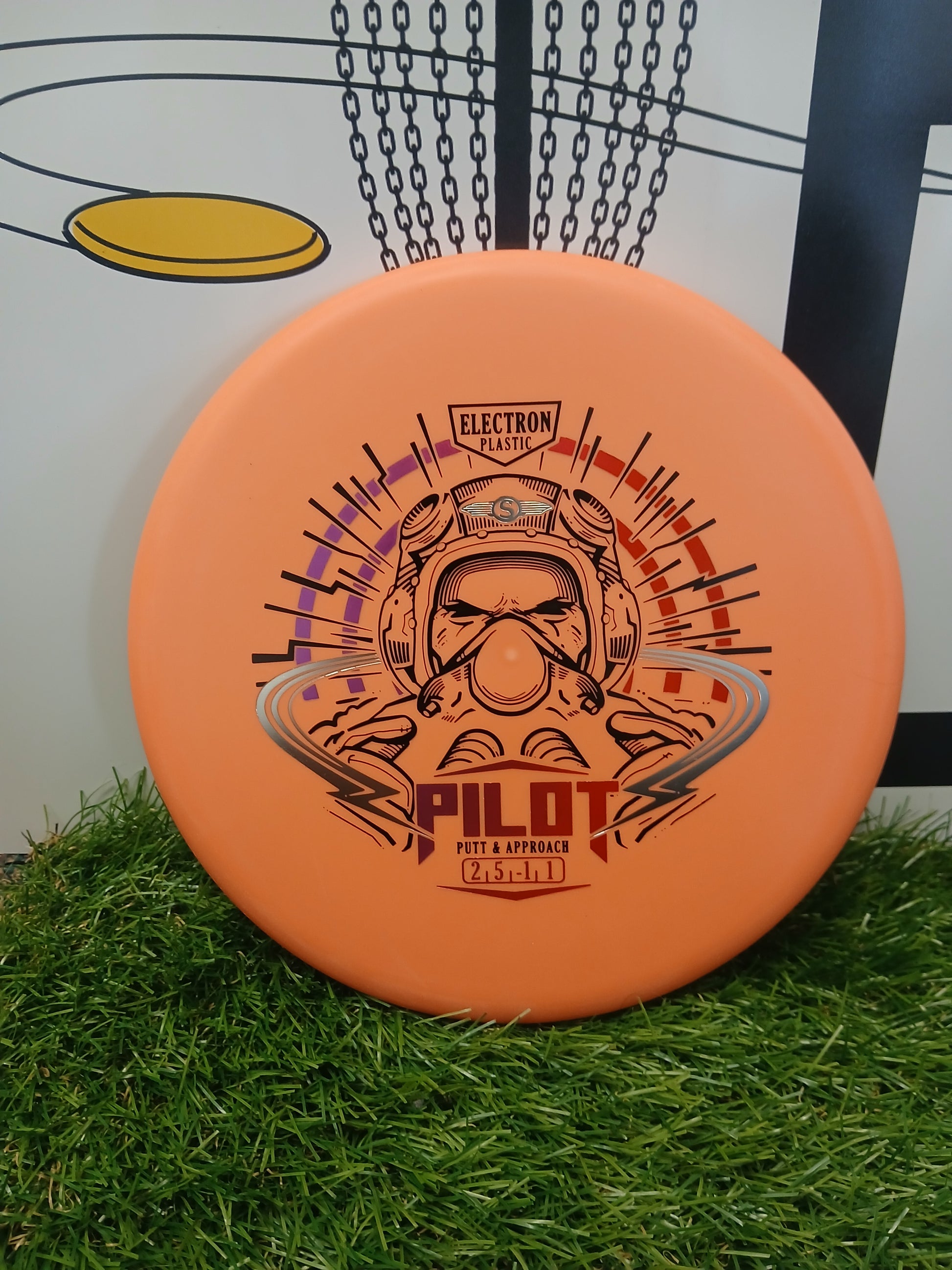 Orange Pilot putter disc golf disc in Electron Plastic, designed for putt & approach shots, resting on grass.