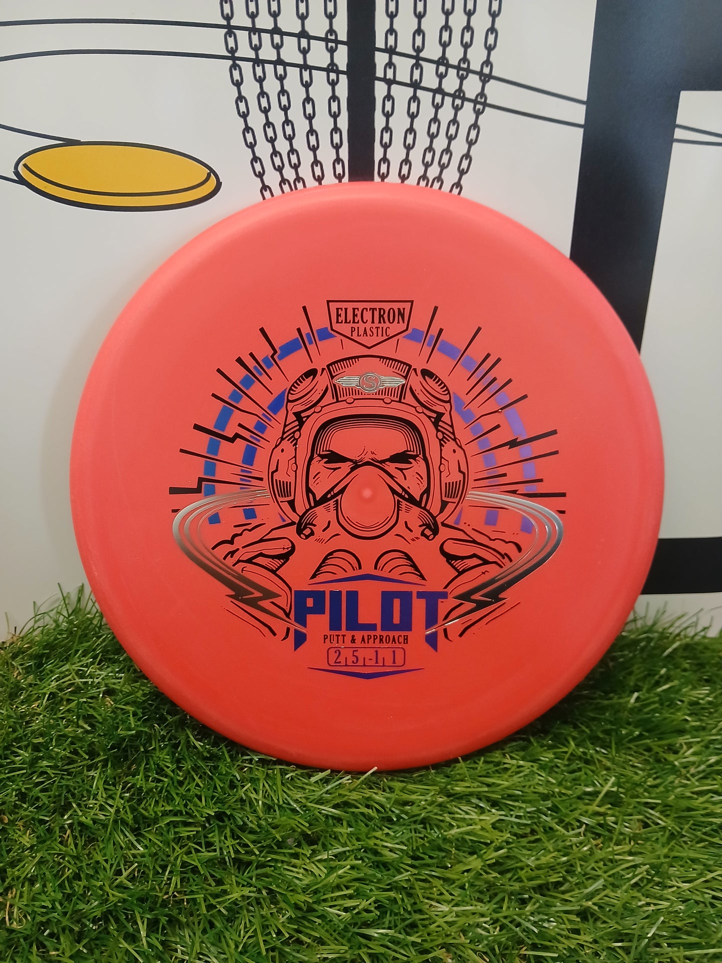 Orange Pilot putter disc golf disc in Electron plastic, designed for putt & approach shots, resting on grass.