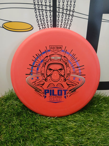 Orange Pilot putter disc golf disc in Electron plastic, designed for putt & approach shots, resting on grass.