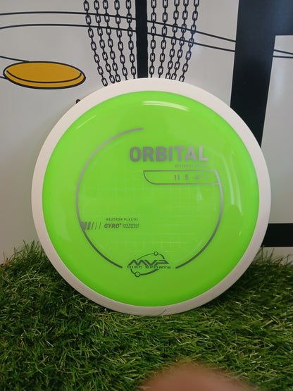 Bright green MVP Disc Sports Orbital distance driver on artificial grass with chain-link backdrop