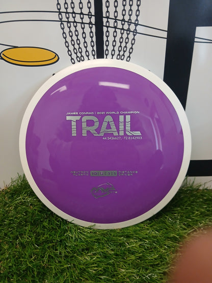 Purple MVP Disc Sports Trail distance driver disc on grass, James Conrad 2021 World Champion model