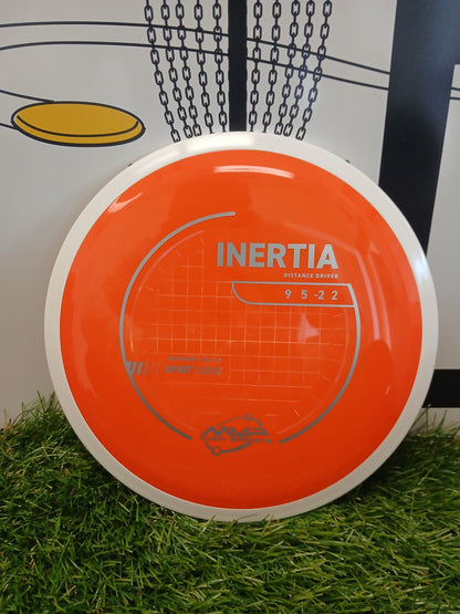 Orange Inertia distance driver disc golf disc on grass, featuring Neutron plastic and Gyro technology