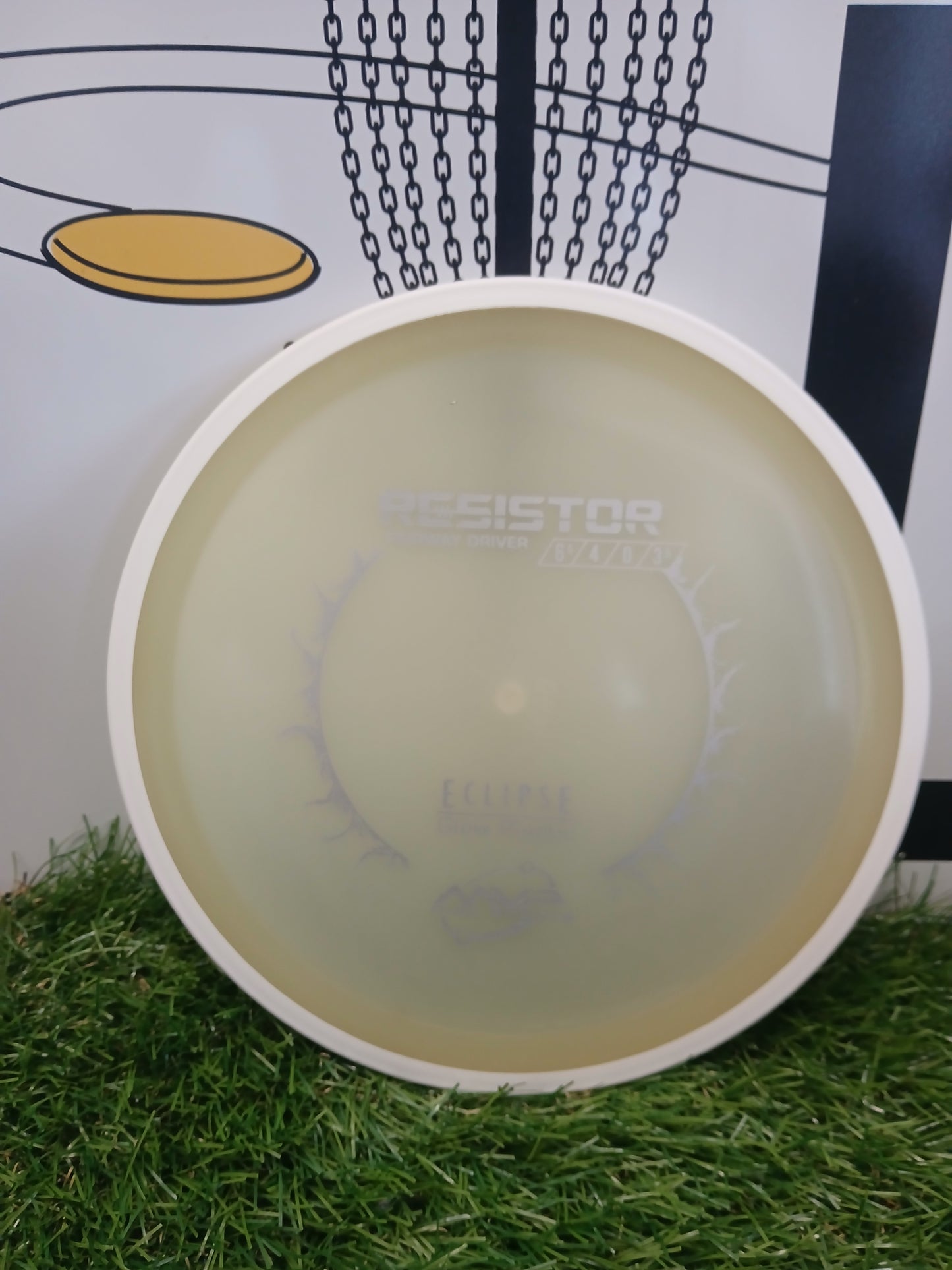 Resistor fairway driver disc golf disc on grass with chain basket background