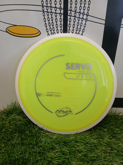 Neon yellow MVP Disc Sports Servo fairway driver on grass, featuring Gyro overmold technology for disc golf.