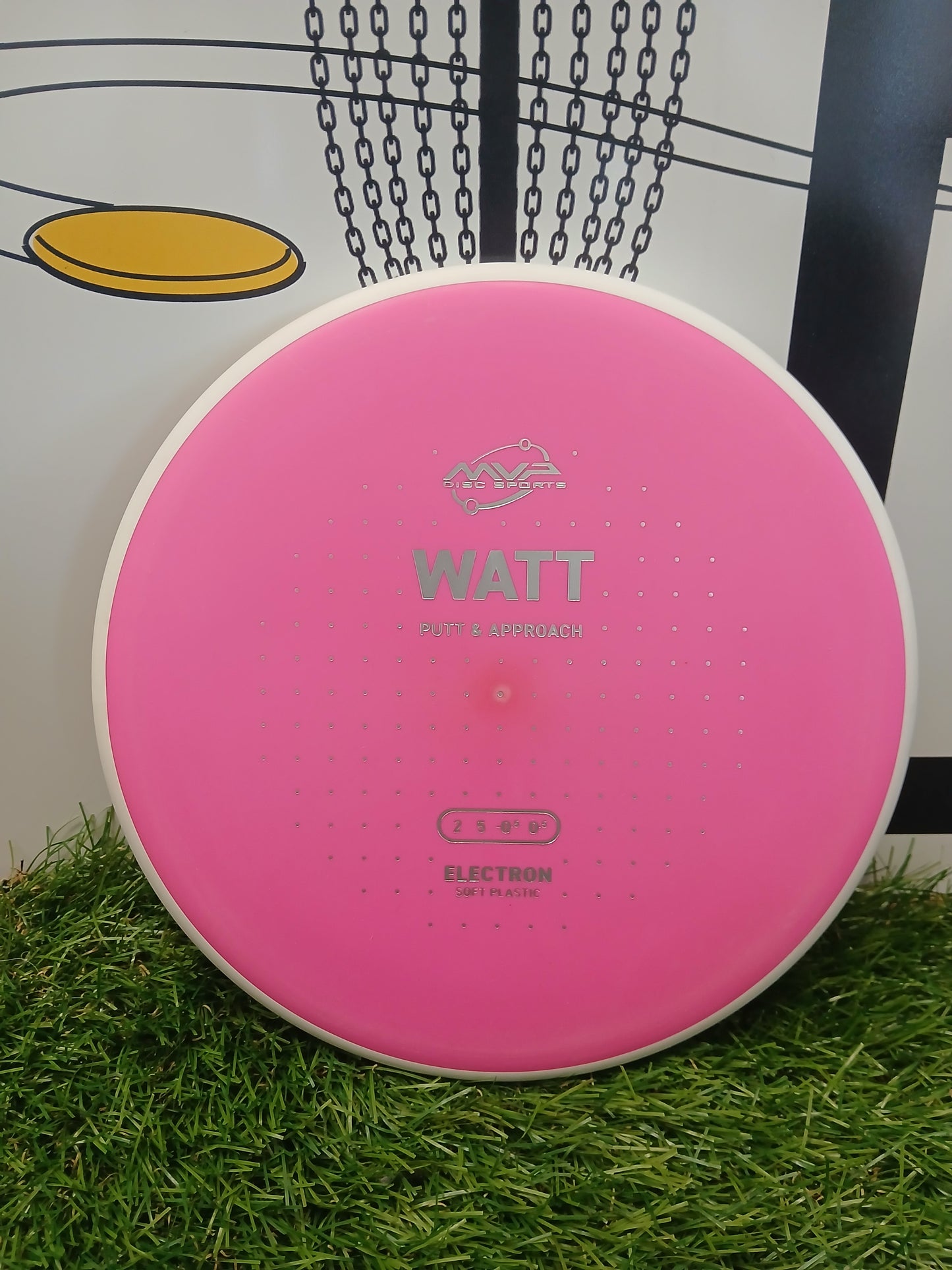 Pink MVP Disc Sports Watt putter disc on grass, Electron soft plastic for disc golf putting and approach shots.