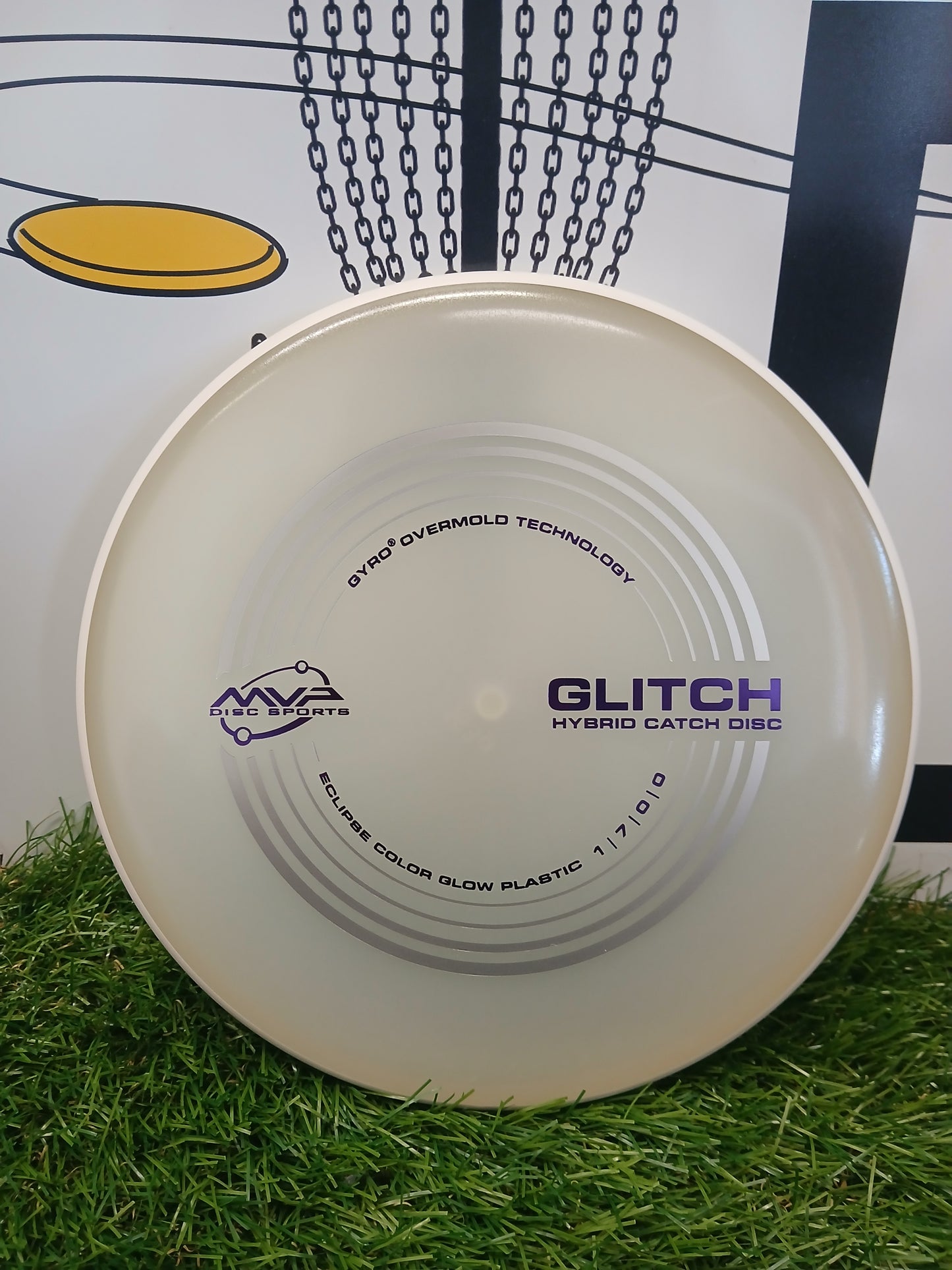 MVP Disc Sports Glitch Hybrid Catch Disc on grass, featuring Gyro Overmold Technology and Eclipse glow plastic.