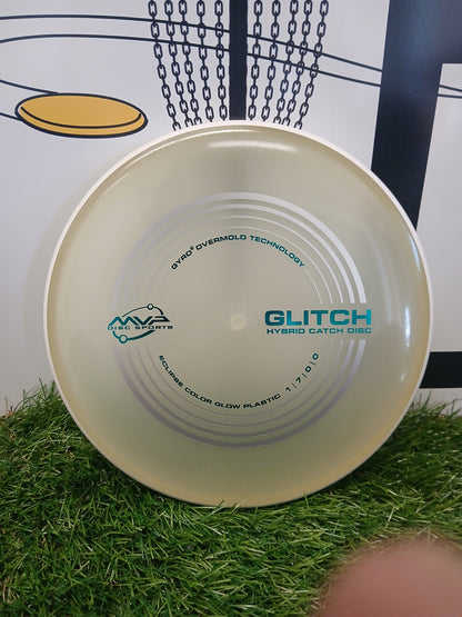 MVP Glitch Hybrid Catch Disc on grass, featuring Gyro Overmold Technology and Eclipse Glow Plastic for disc golf.