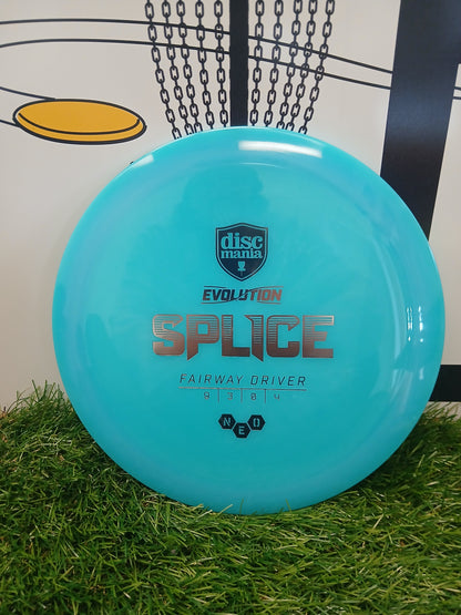 Discmania Evolution Splice fairway driver disc golf disc on grass near basket