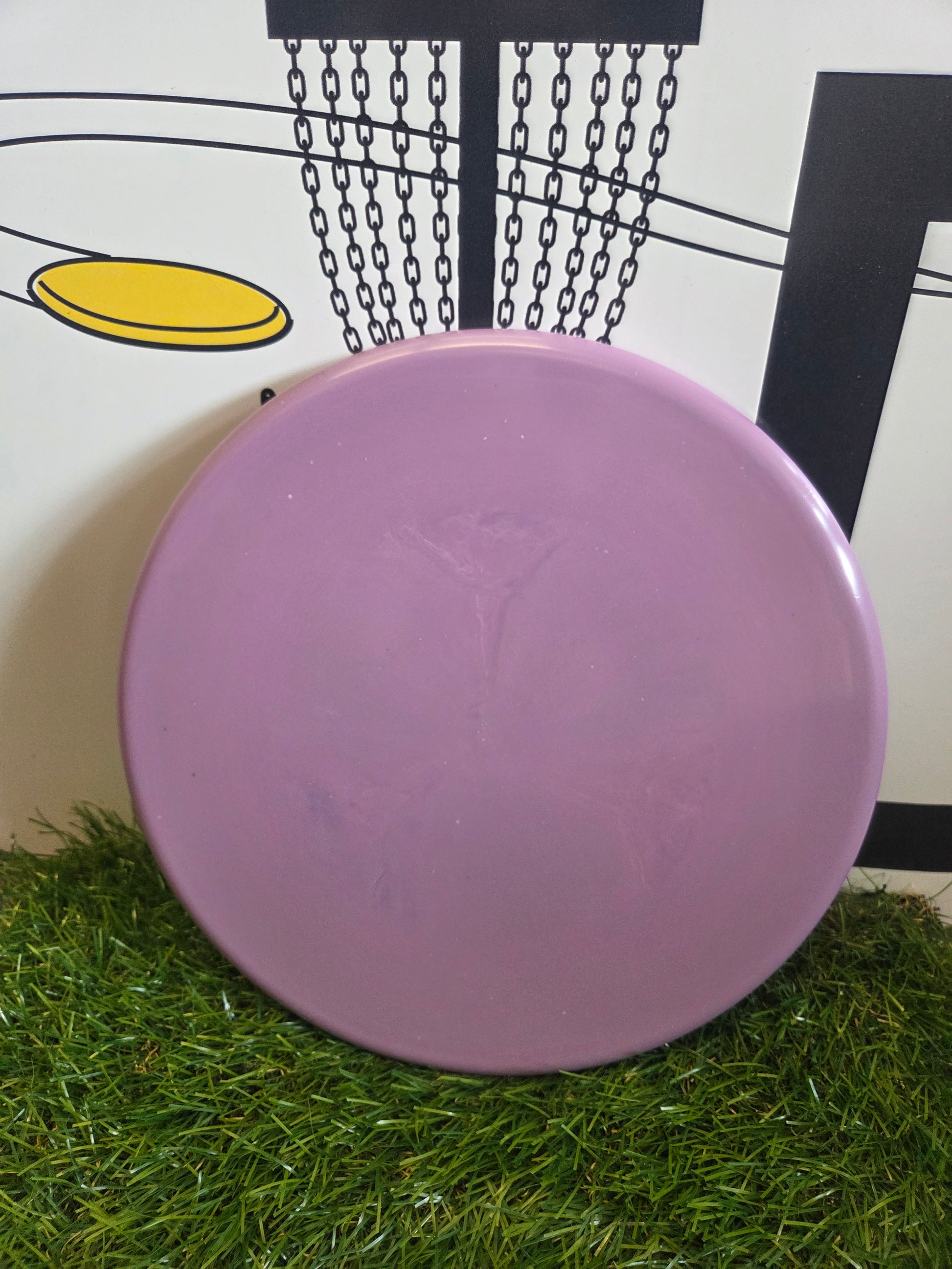 Purple disc golf disc on artificial grass with basket graphic background