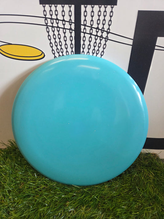 Bright blue disc golf disc on artificial grass with chain basket background